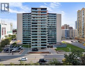 A tall building with a parking lot in front of it.