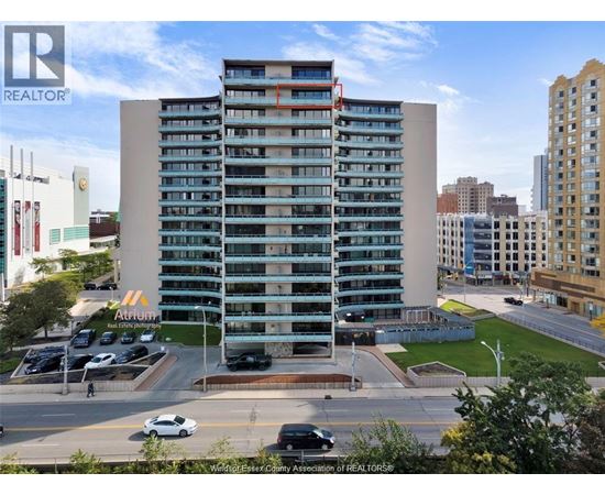 A tall building with a parking lot in front of it.