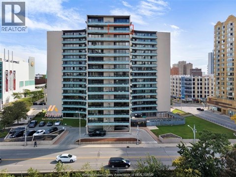 A tall building with a parking lot in front of it.
