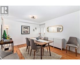 A dining room with a wooden table and grey chairs.
