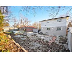 A backyard with a patio and a small building.