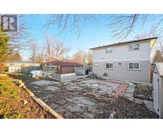 A backyard with a patio and a small building.
