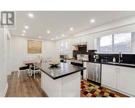 A kitchen with a black countertop and white cabinets.