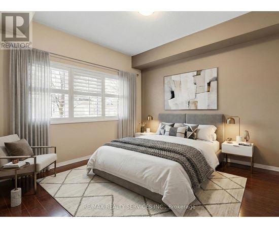 A bedroom with a large bed, a chair, and a painting on the wall.