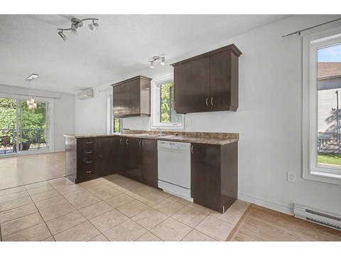 A kitchen with brown cabinets and a white dishwasher.