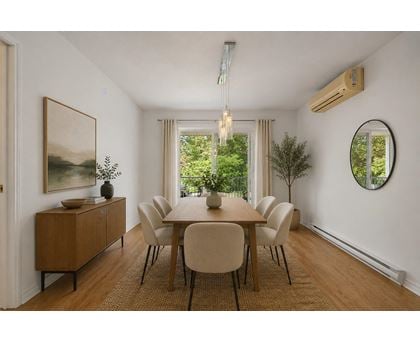 A dining room with a wooden table and chairs.