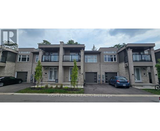 A row of townhouses with a car parked in front of the first one.