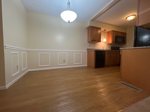 A kitchen with wooden floors and white walls.