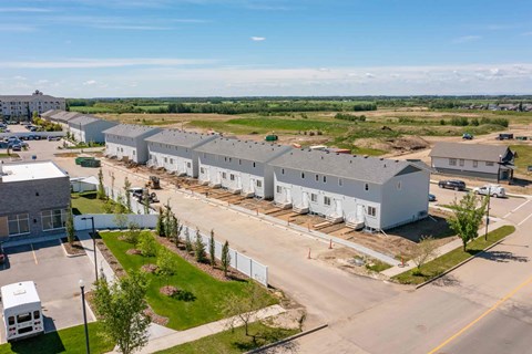A construction site with a building under construction surrounded by a white fence.