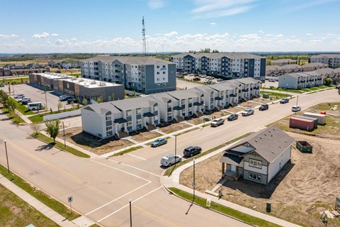 A large apartment complex with a parking lot in front.