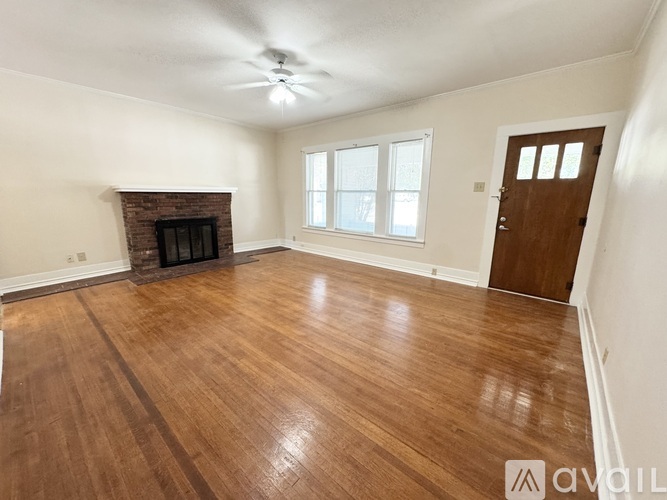 A room with a fireplace and wooden flooring.