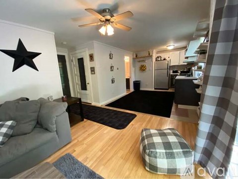 A living room with a grey couch and a black star on the wall.