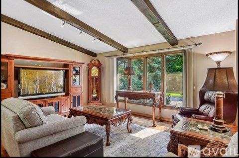A living room with a grey couch and a wooden coffee table.