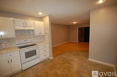 A kitchen with white cabinets and a stone backsplash.