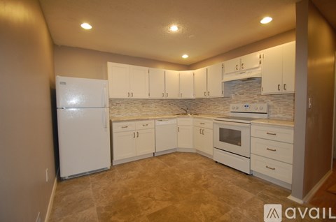 A kitchen with white appliances and cabinets.