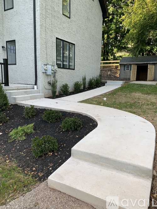 A white house with a concrete walkway in front.