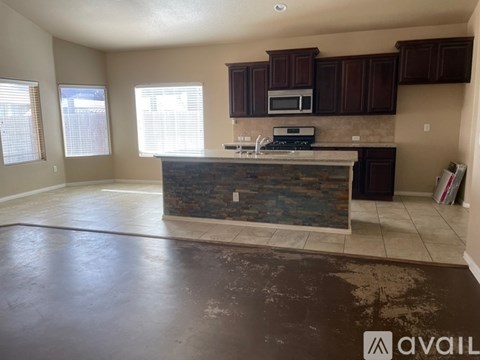 A kitchen with brown cabinets and a stone backsplash is available.
