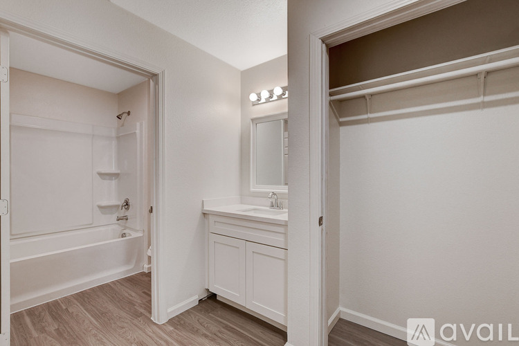 A bathroom with a bathtub, sink, and mirror.