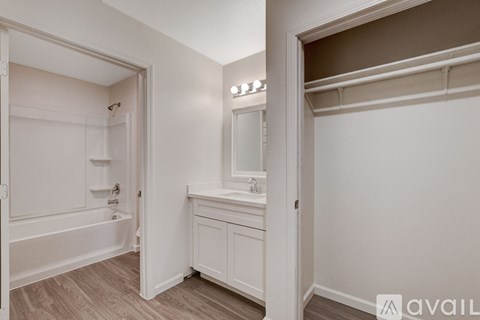 A bathroom with a bathtub, sink, and mirror.