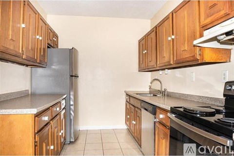 A kitchen with wooden cabinets and a black stove top oven.