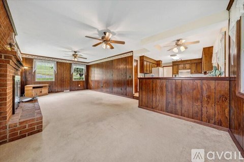 A spacious room with wooden walls and ceiling fans.