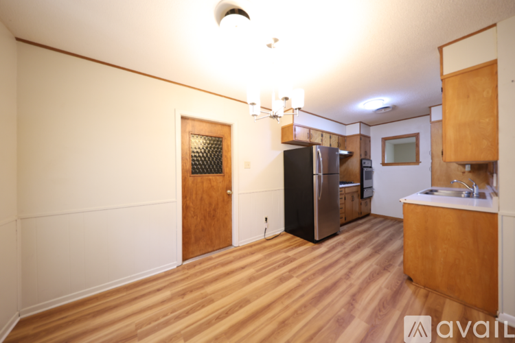 A kitchen with wooden floors and a refrigerator.