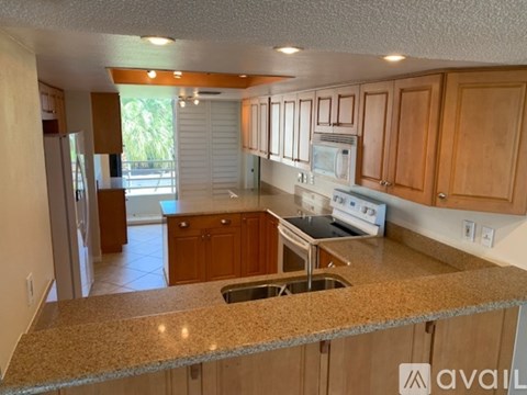 A kitchen with wooden cabinets and granite countertops.