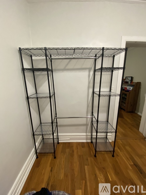 A tall metal shelf unit stands in a corner of a room.