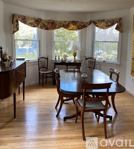 A dining room with a wooden table and chairs.