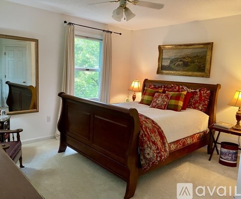A bedroom with a large bed and a painting on the wall.