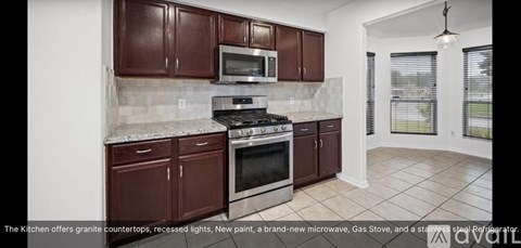 A kitchen with granite countertops, recessed lights, new paint, a brand new microwave, gas stove, and a stainless steel refrigerator.
