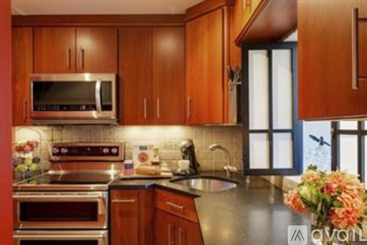 A kitchen with wooden cabinets and a stainless steel oven.