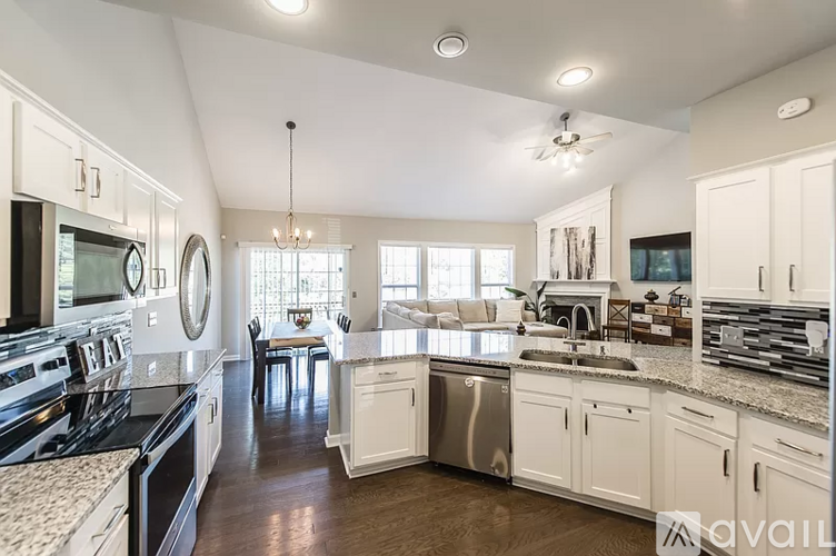 A modern kitchen with white cabinets and stainless steel appliances.