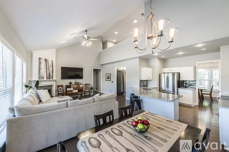 A modern kitchen and living room with a dining table set for two.