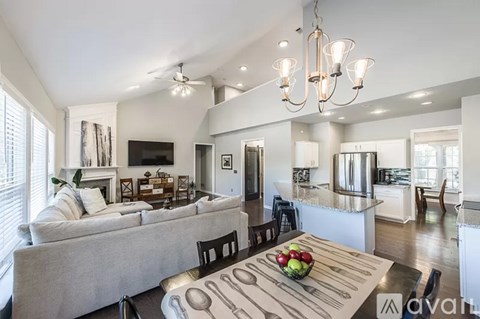 A modern kitchen and living room with a dining table set for two.