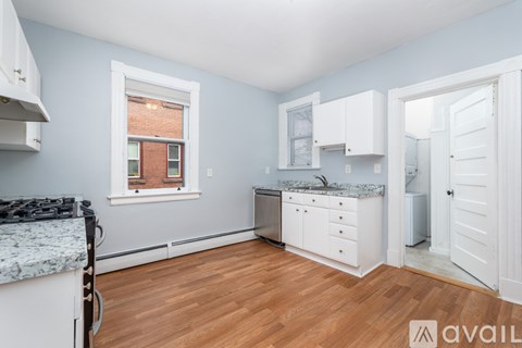 A kitchen with a stove top oven and a window.