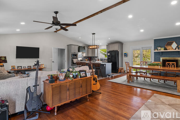 A living room with a guitar and a TV on the wall.