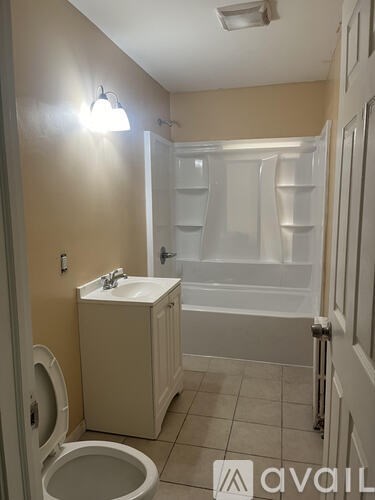 A bathroom with a toilet, sink, and bathtub.