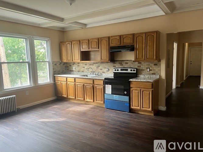 A kitchen with wooden cabinets and a blue dishwasher.