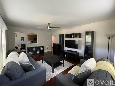 A living room with a grey couch and a black coffee table.