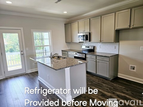 A kitchen with a countertop and cabinets with a note that says "Refrigerator will be provided before moving".