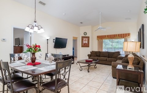 A living room with a dining table set for six.