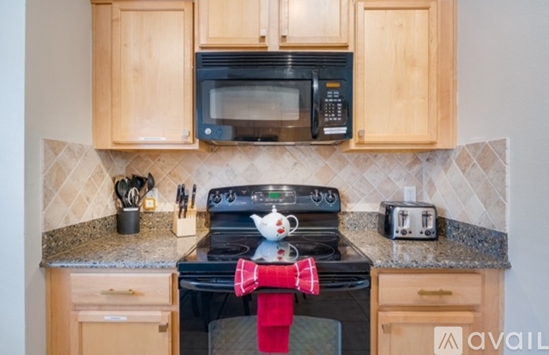 A kitchen with wooden cabinets and a black stove top.