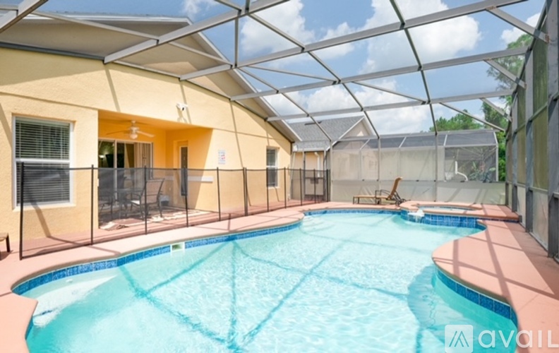 A swimming pool under a glass roof in a sunny day.