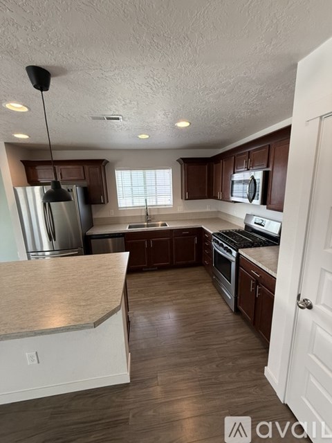 A kitchen with wooden cabinets and a stainless steel refrigerator.
