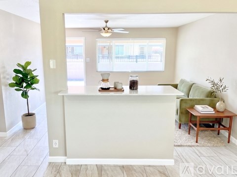 A living room with a white reception desk and a green couch.