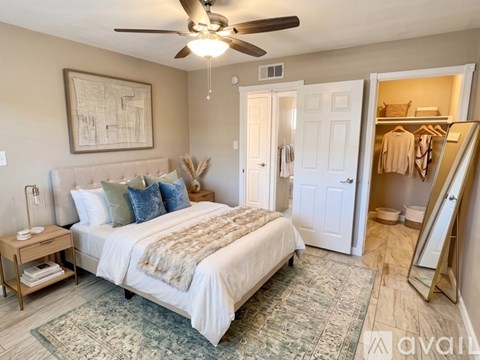 A bedroom with a large bed and a ceiling fan.