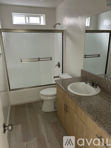 A bathroom with a sink, toilet and a glass shower stall.