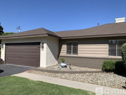 A house with a brown garage door and a grey roof.