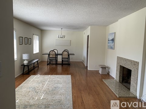 A living room with a fireplace and a rug on the floor.